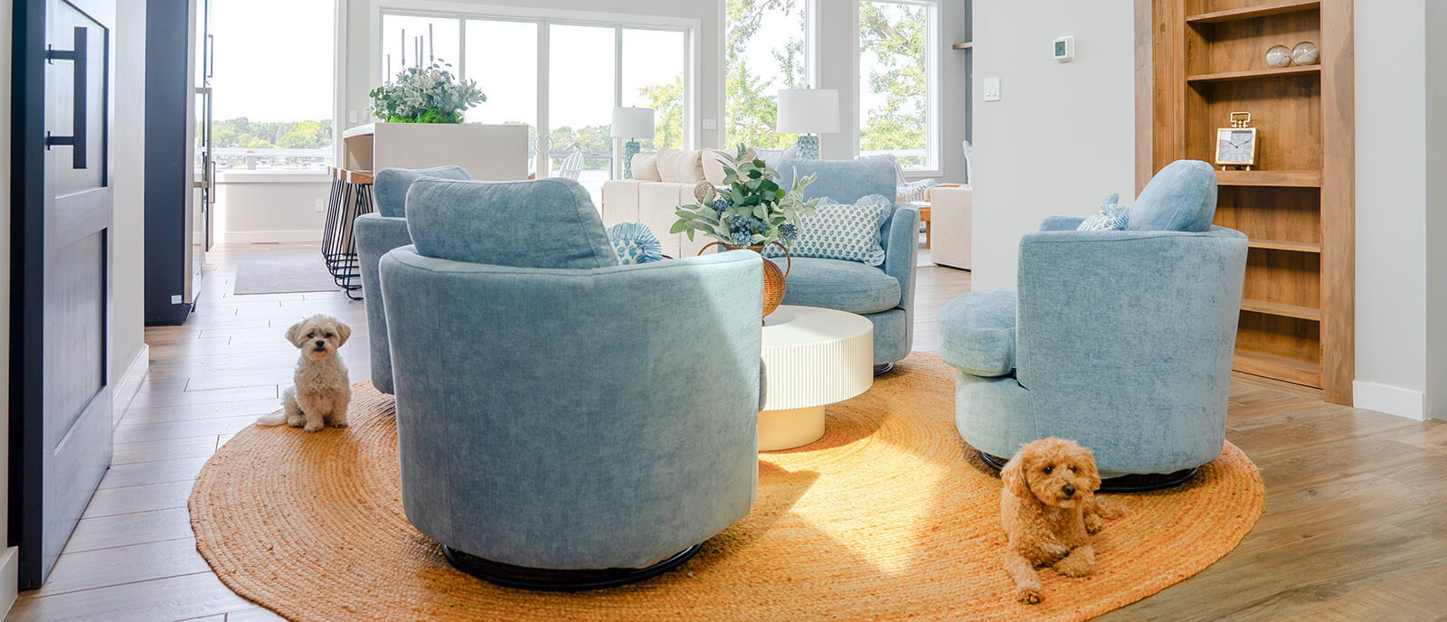 Okoboji-Lake-House-15 Bright Okoboji Lake House living room with soft blue chairs, neutral furnishings, and relaxed coastal inspired design