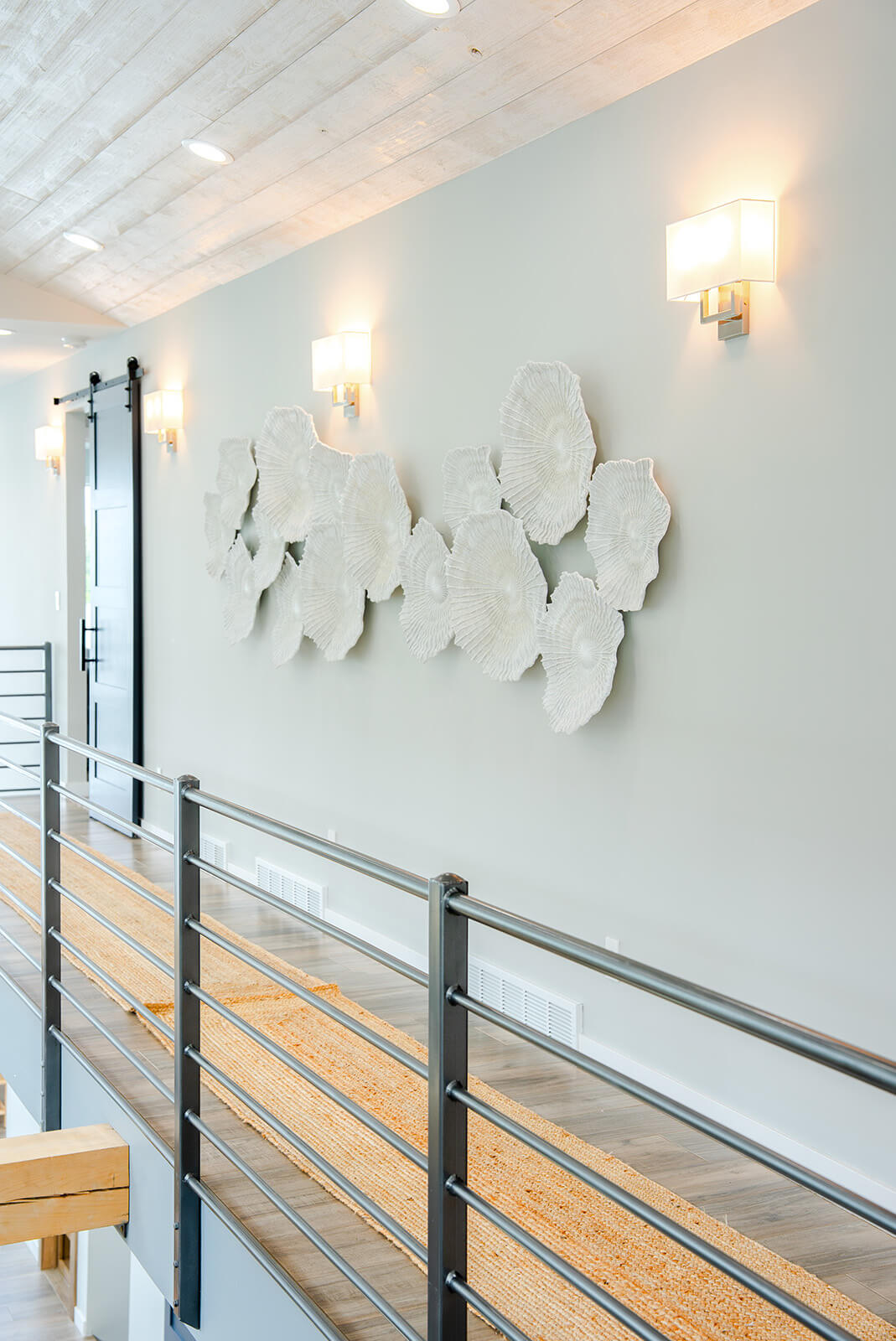 Okoboji-Lake-House-17 Upstairs hallway with sculptural white wall art, natural light, and a minimalist neutral design aesthetic