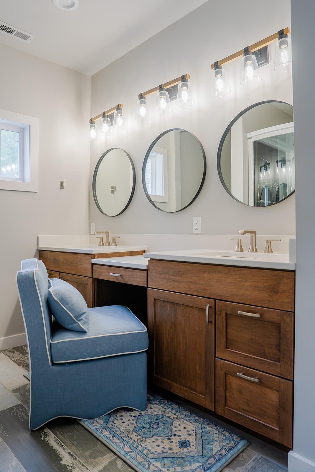 Okoboji-Lake-House-22 Contemporary lake house bathroom with round mirrors, white cabinetry and marble countertops