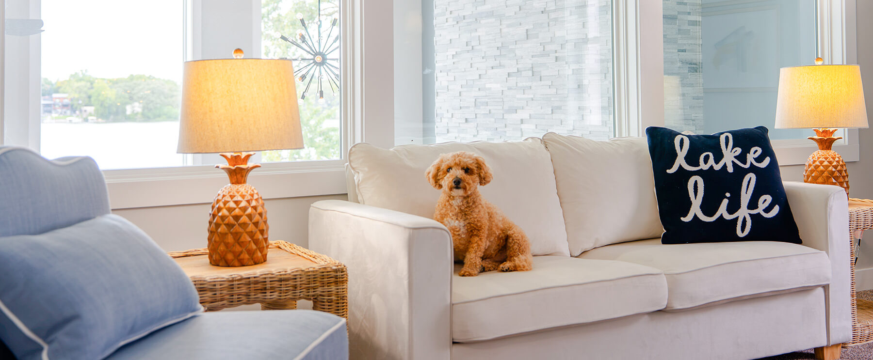 Okoboji-Lake-House-25 Chic lake house sitting area with a soft neutral sofa complemented by sculptural gold pineapple lamps