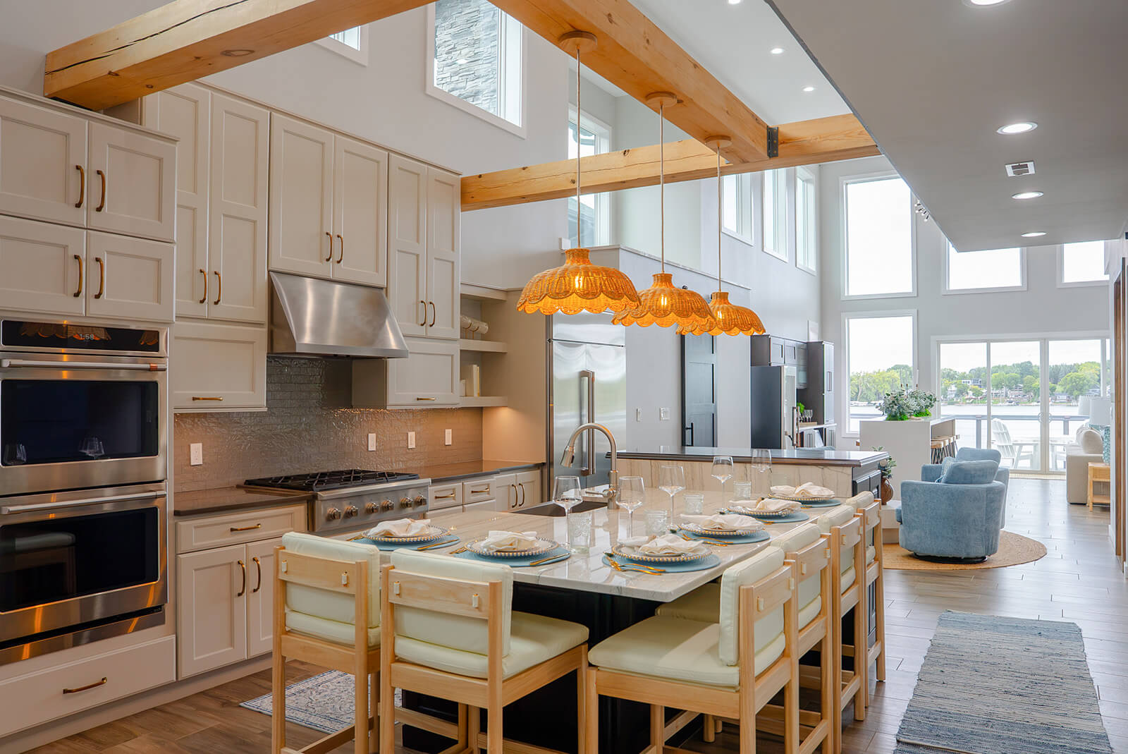 Okoboji-Lake-House-27 Open kitchen and dining area with crisp white cabinetry and natural wood beams creating a bright, sophisticated lake house retreat