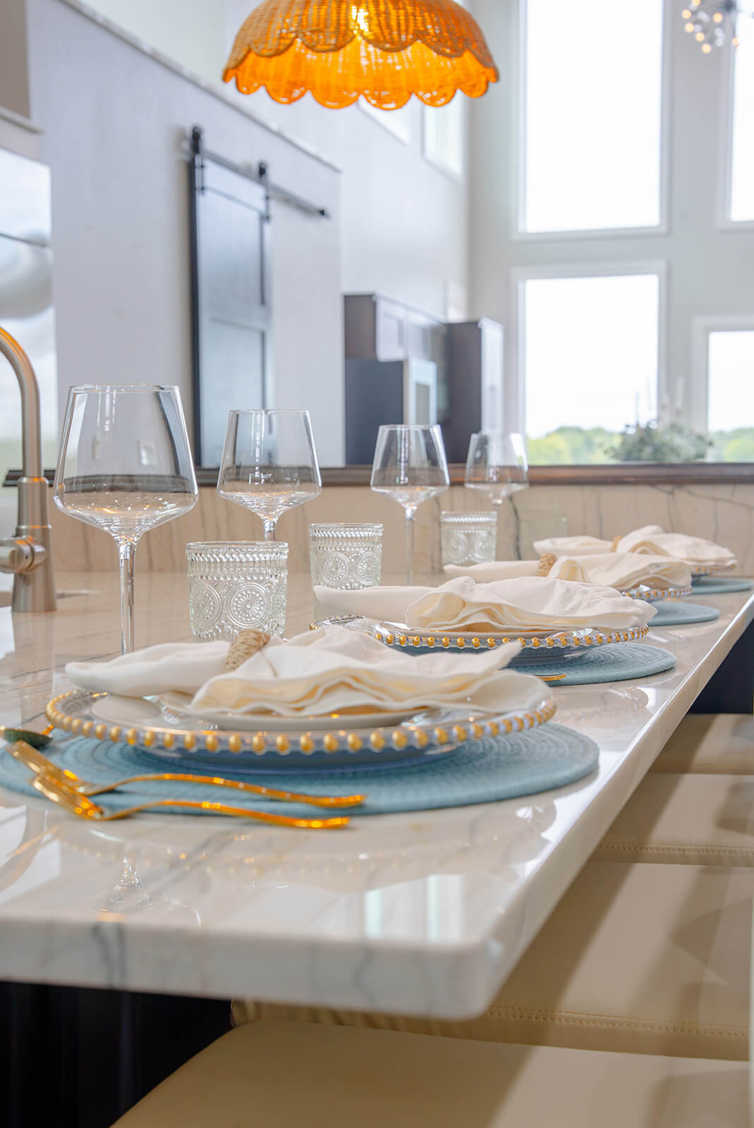 Okoboji-Lake-House-28 Serene dining space filled with natural light from oversized windows, creating an airy setting around a refined neutral table