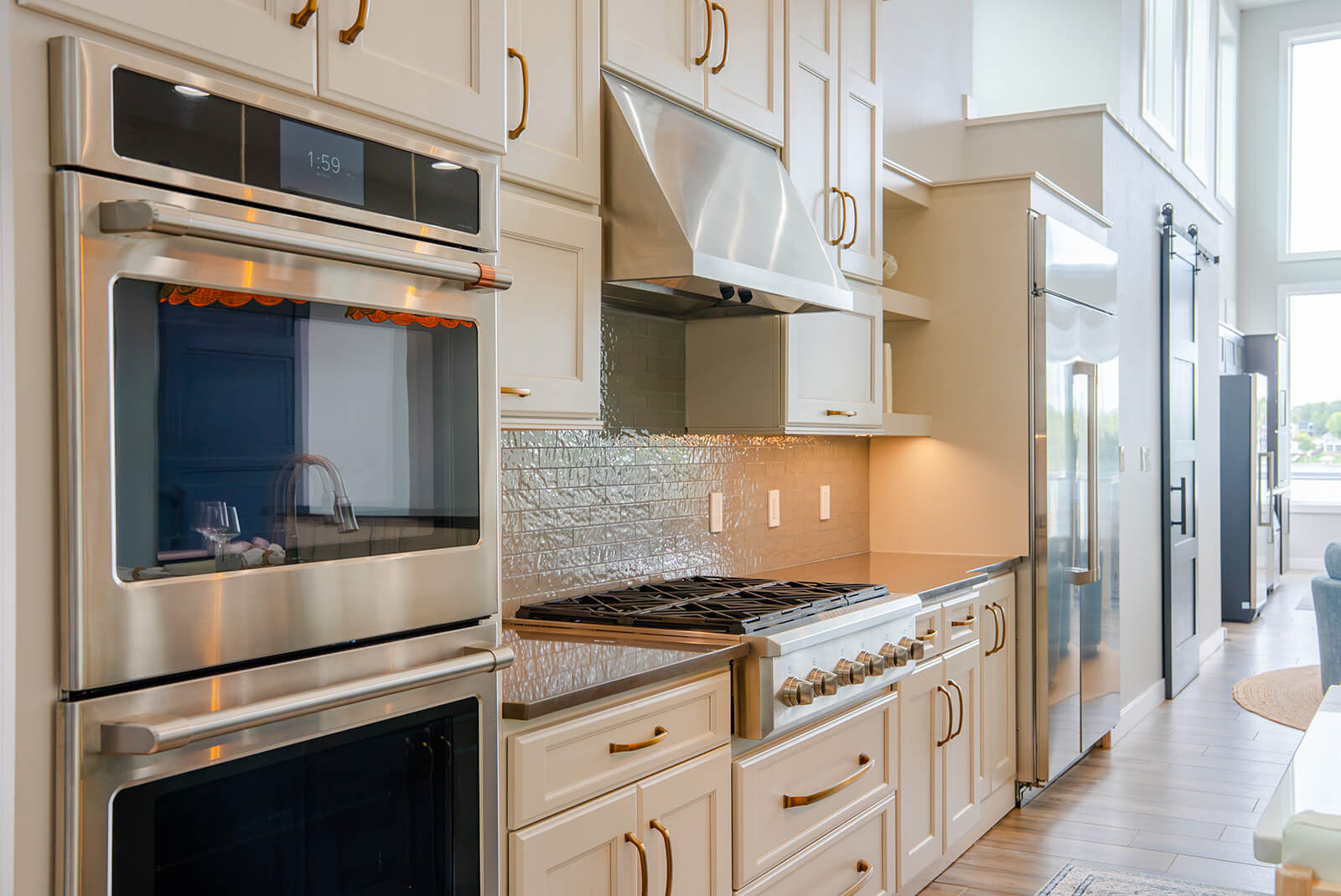 Okoboji-Lake-House-29 Bright kitchen with crisp white cabinetry balanced by warm wood accents, creating an airy, refined, and minimalist space
