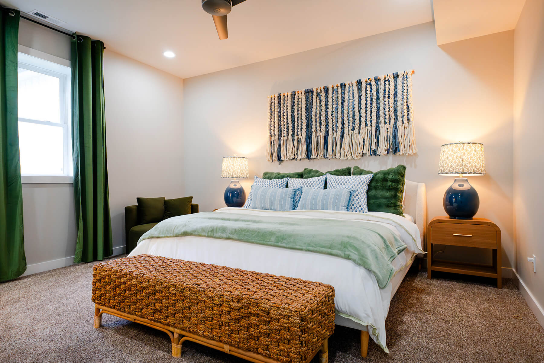 Okoboji-Lake-House-32 Cozy Okoboji Lake House bedroom with textured blue wall art, layered bedding and green accents