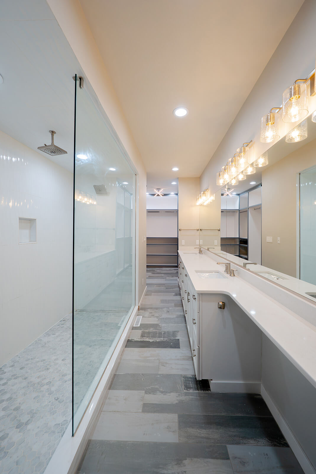 Okoboji-Lake-House-37 Bright bathroom with glass shower, white tile, natural wood cabinetry, and clean minimalist design