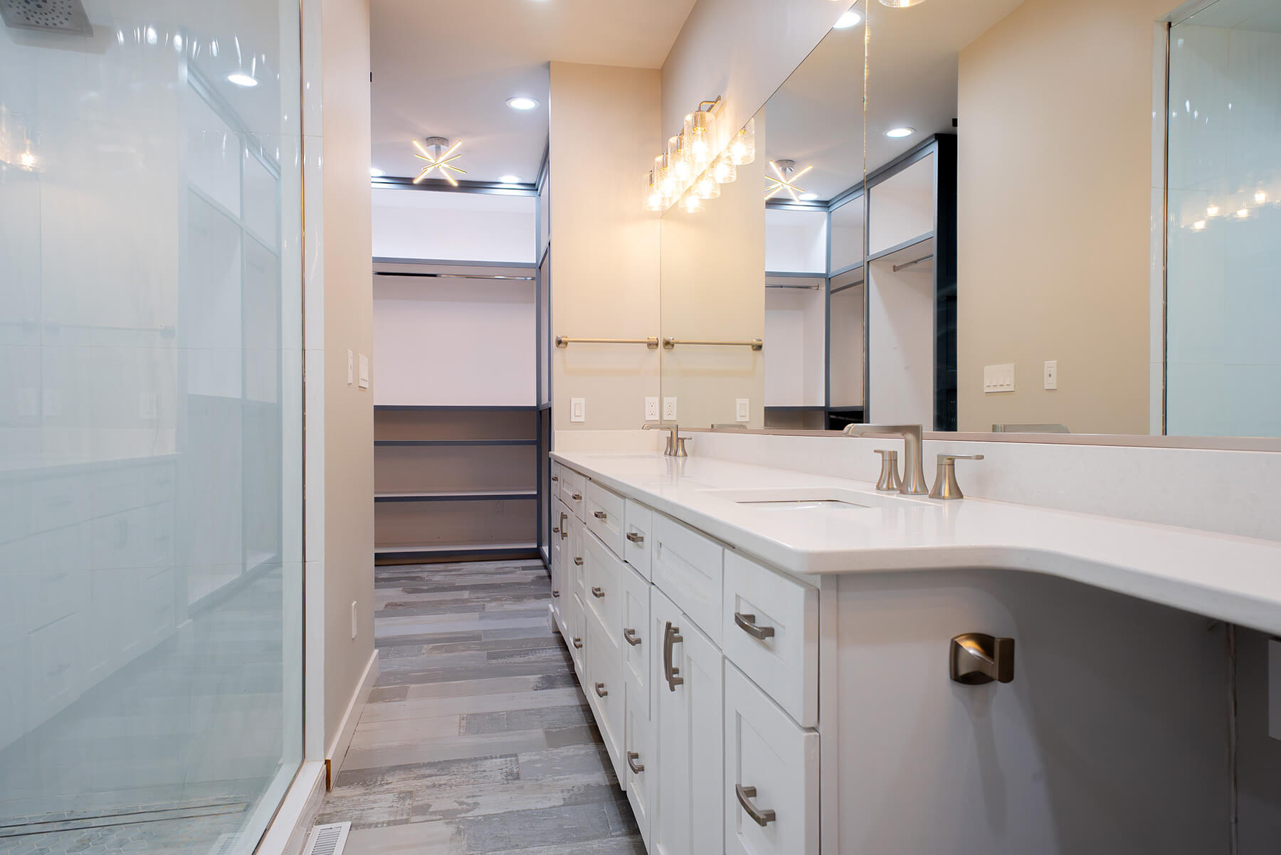 Okoboji-Lake-House-38 Airy bathroom with glass shower, light cabinetry, and marble surfaces creating a relaxed, sophisticated atmosphere
