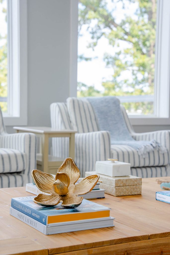 Okoboji-Lake-House-5 Light-filled seating area with striped chairs, blue accents, and soft neutral textures