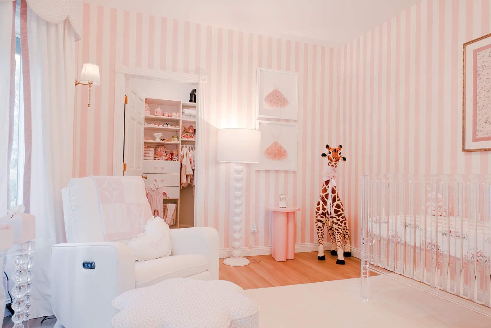 Storybook-1 Whimsical pink nursery with white furnishings, striped walls, soft lighting, and playful decorative accents