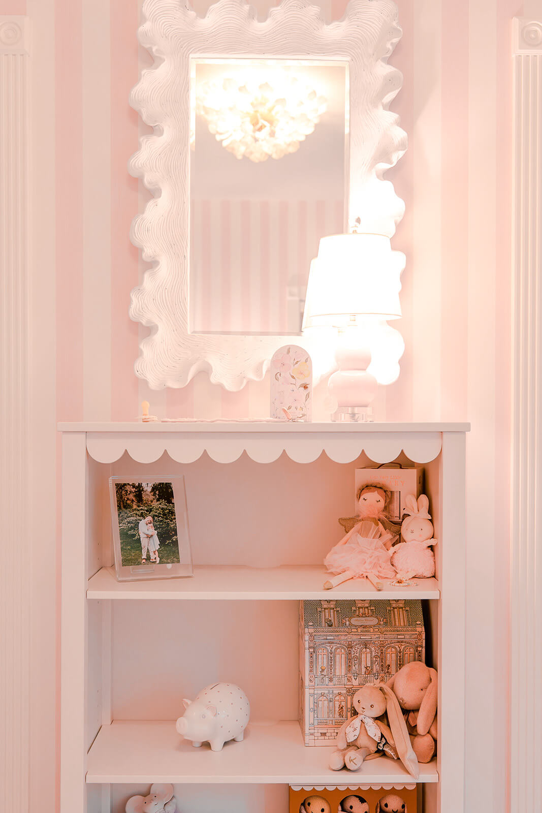 Storybook-13 Feminine nursery vignette with pink striped walls, ornate white mirror, and delicate decorative styling