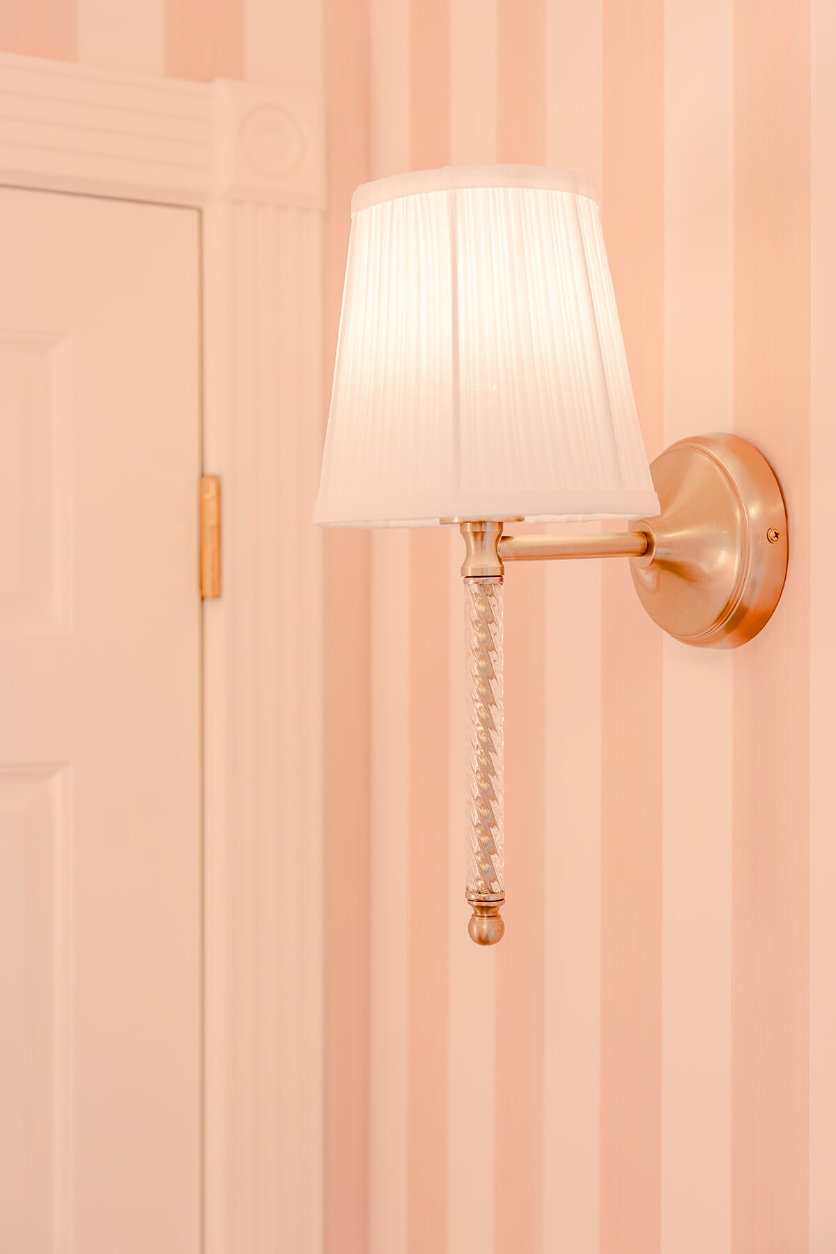 Storybook-15 Elegant wall sconce with a soft fabric shade complementing the delicate pink nursery design