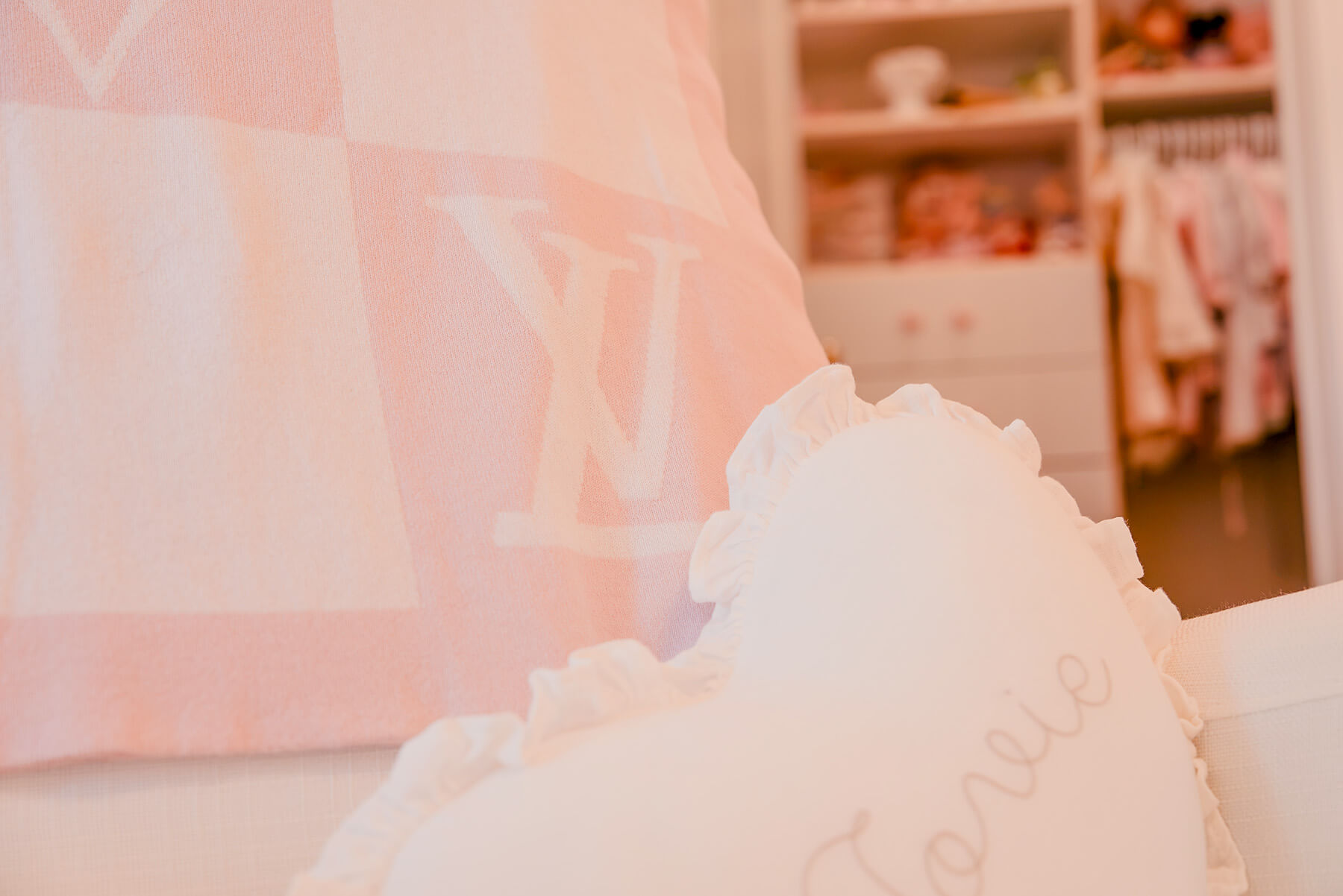 Storybook-16 Close-up of soft pink nursery textiles layered with delicate patterns and feminine decorative details