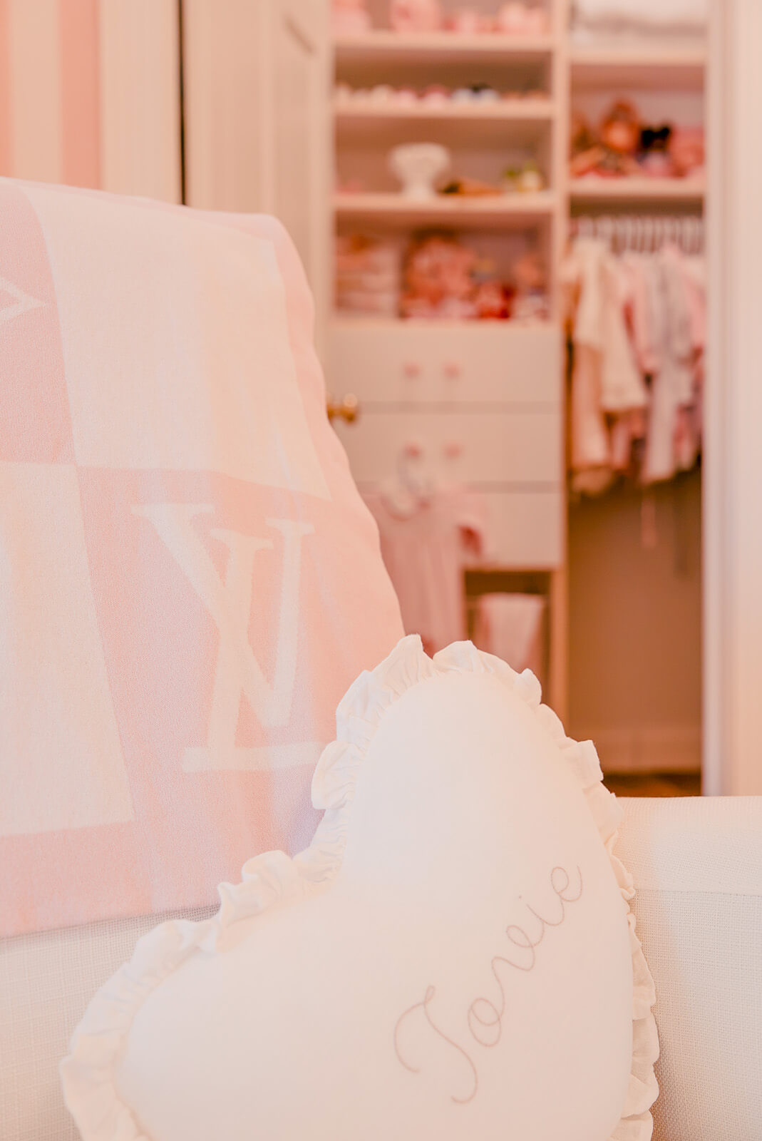 Storybook-17 Soft pink nursery vignette with layered textiles, floral details, and warm natural wood accents