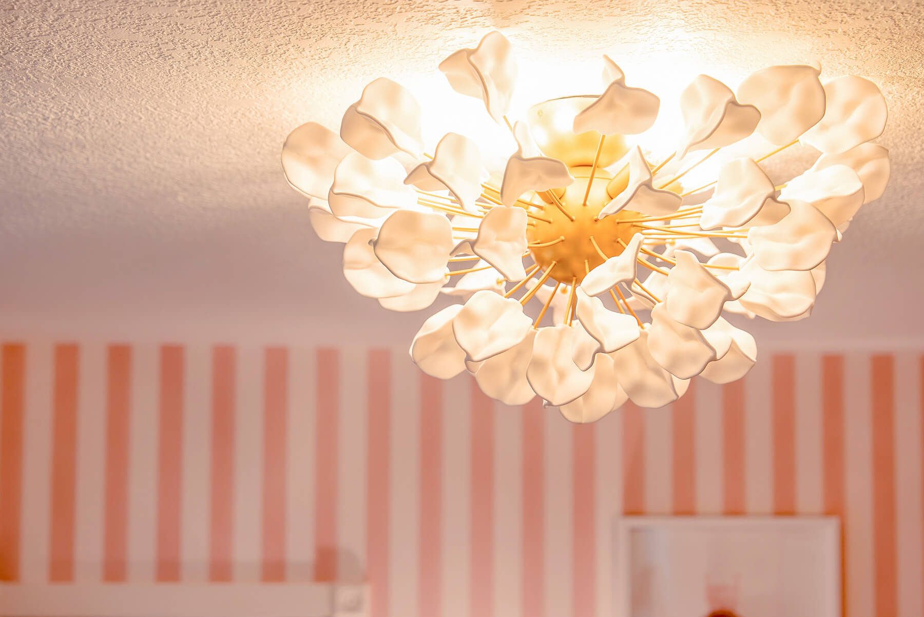 Storybook-18 Sculptural floral chandelier with delicate petals adding an elegant focal point to the pink nursery