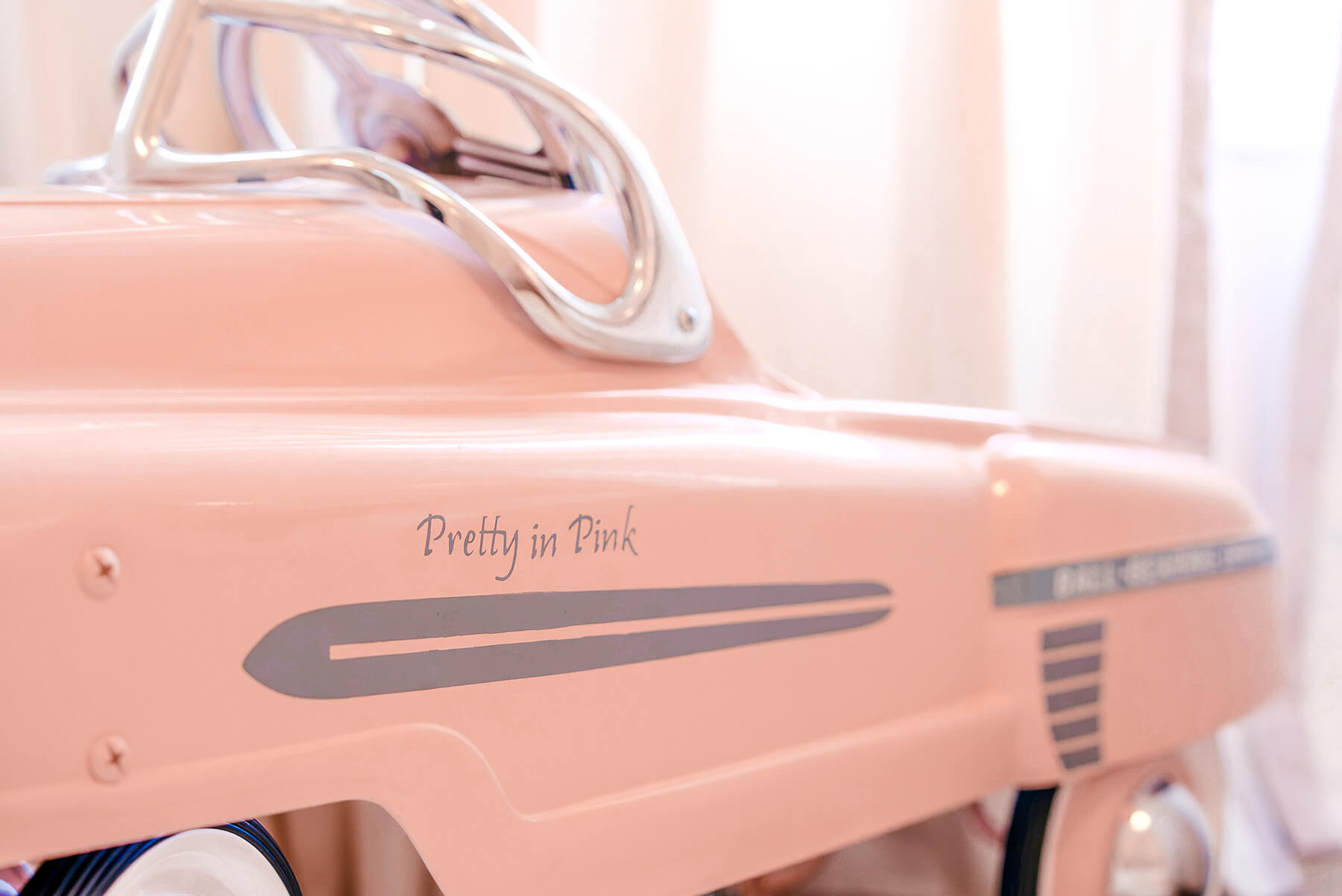 Storybook-21 Soft pink nursery vignette with layered textiles, floral details, and warm natural wood accents