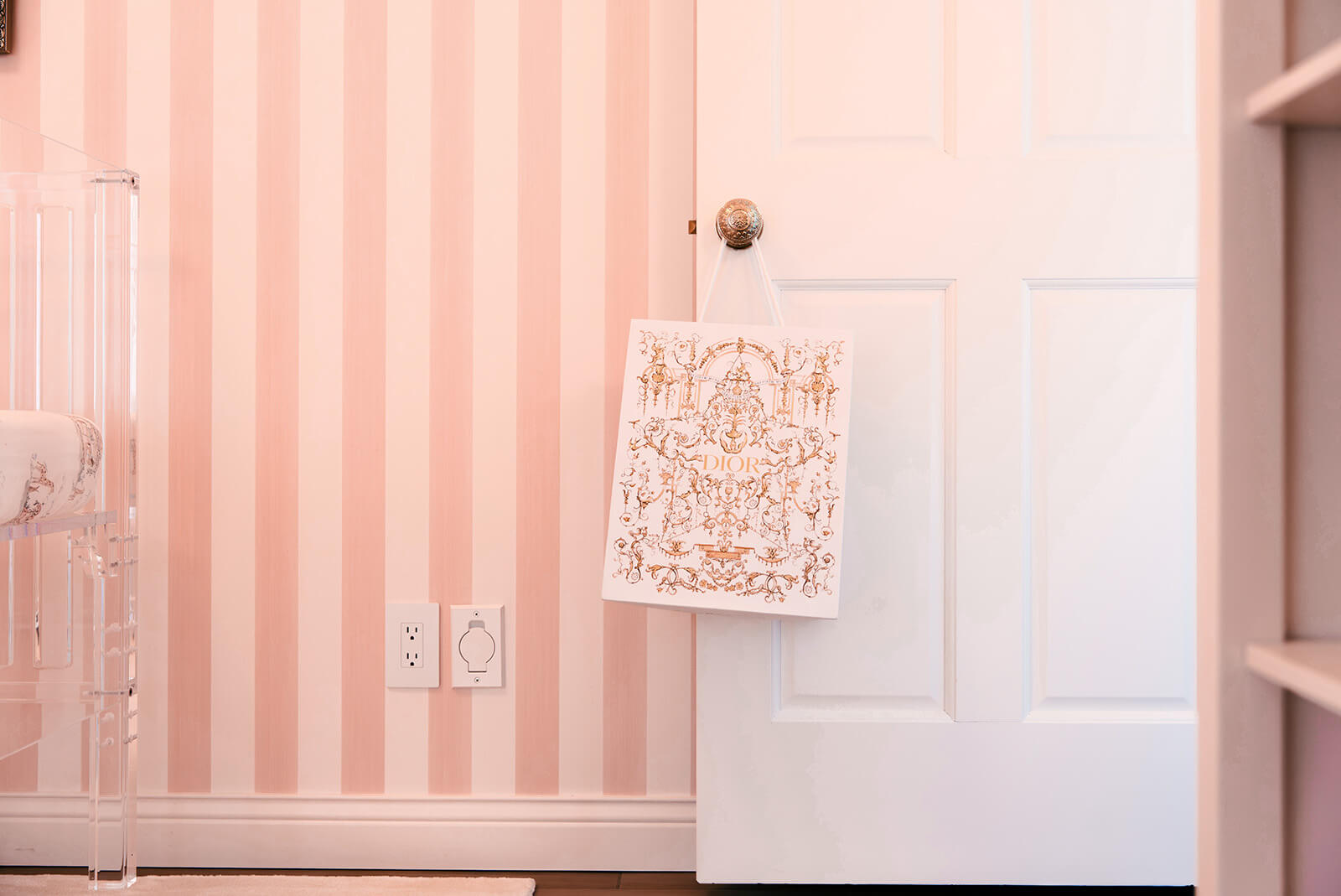 Storybook-24 Pink striped nursery wall with a delicate hanging textile adding a playful decorative detail