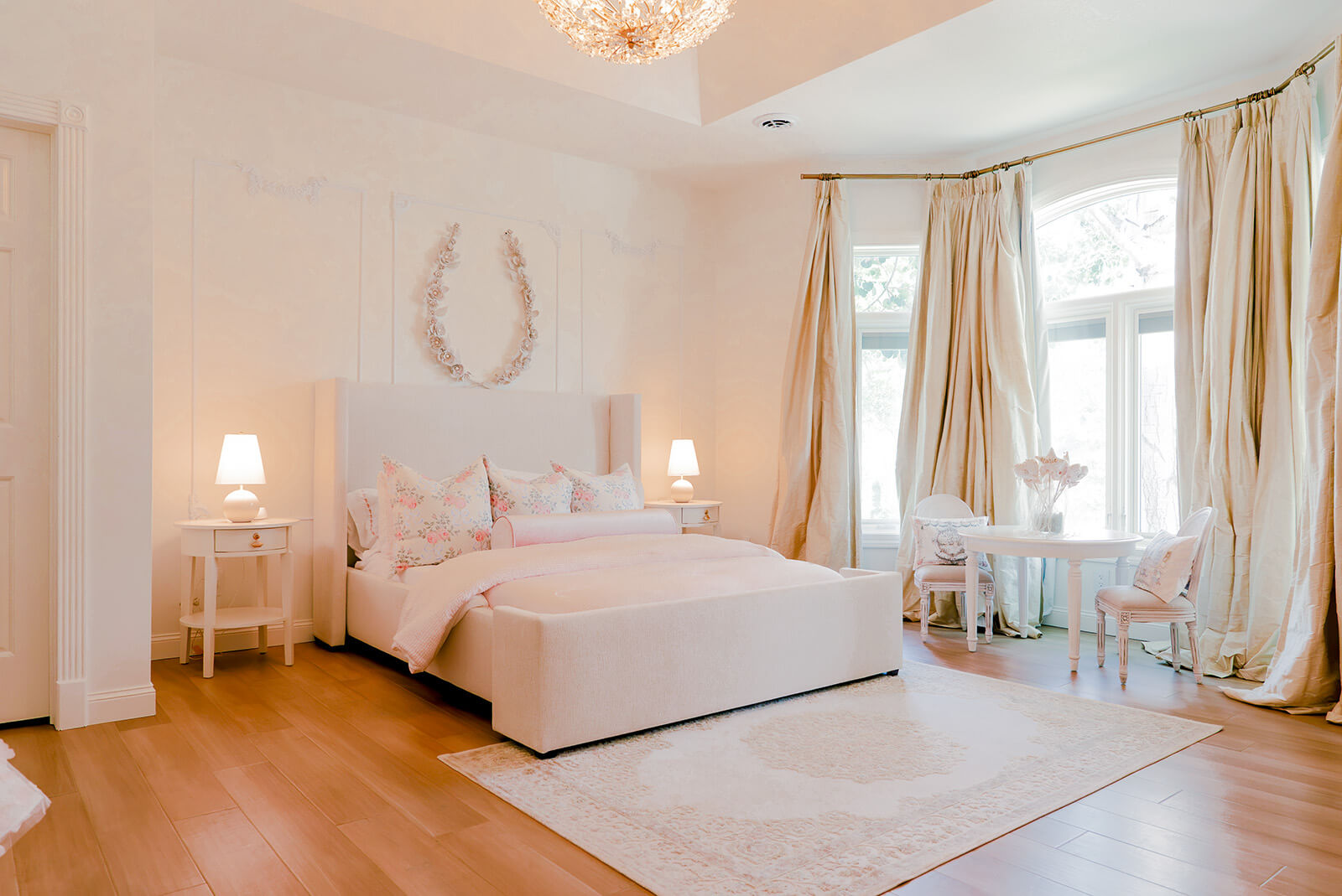 Storybook-28 Elegant bedroom with soft pink bedding, floral pillows, delicate lighting, and flowing neutral curtains