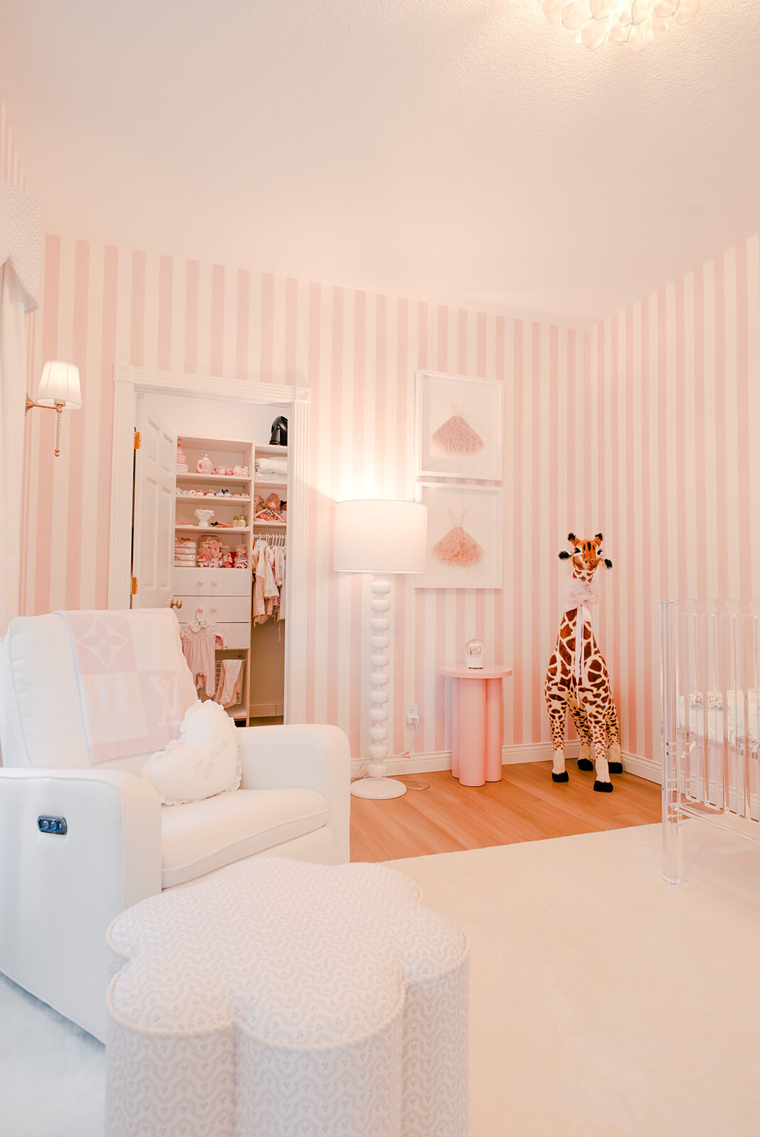 Storybook-3 Playful nursery with pink striped walls, white furnishings, whimsical artwork, and soft layered textures