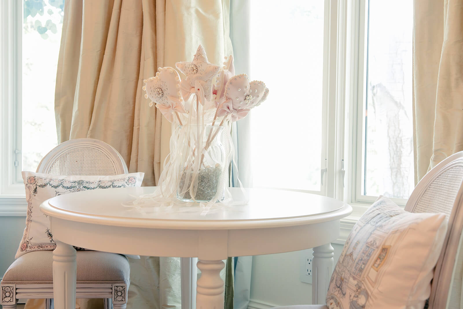 Storybook-31 Delicate arrangement of princess wands on a bedside table, illuminated by natural light through sheer curtains
