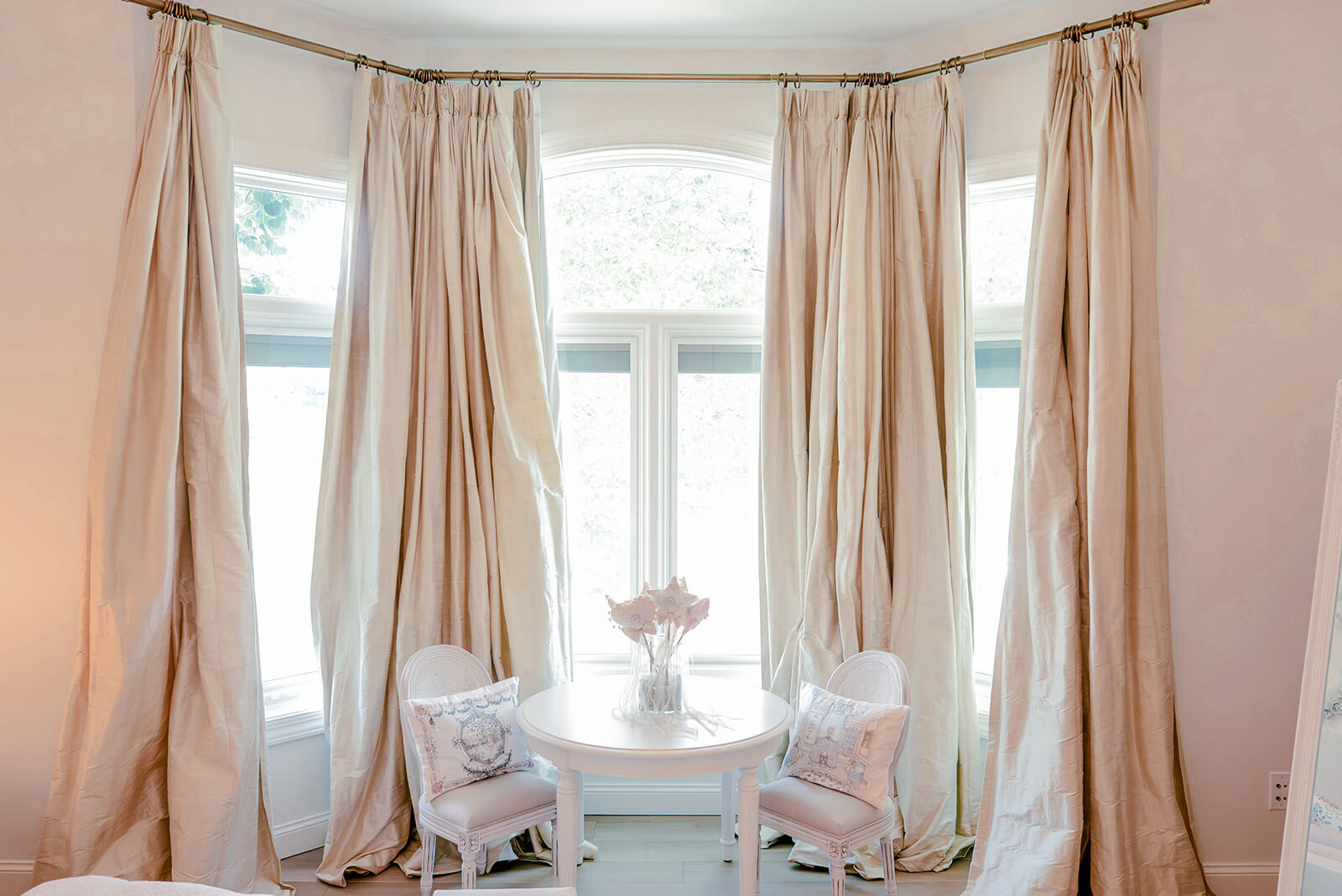 Storybook-36 Bright bedroom with tall windows, flowing neutral curtains, and soft natural light creating an airy atmosphere