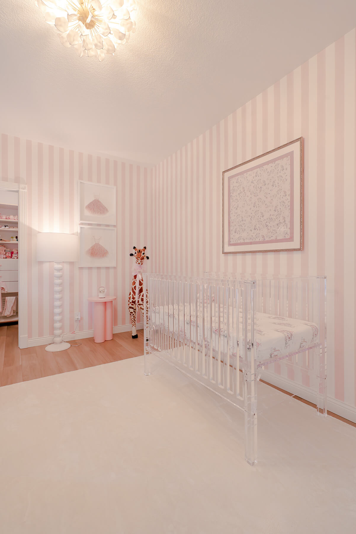 Storybook-6 Soft pink nursery with white crib, striped walls, delicate artwork, and thoughtfully layered feminine details