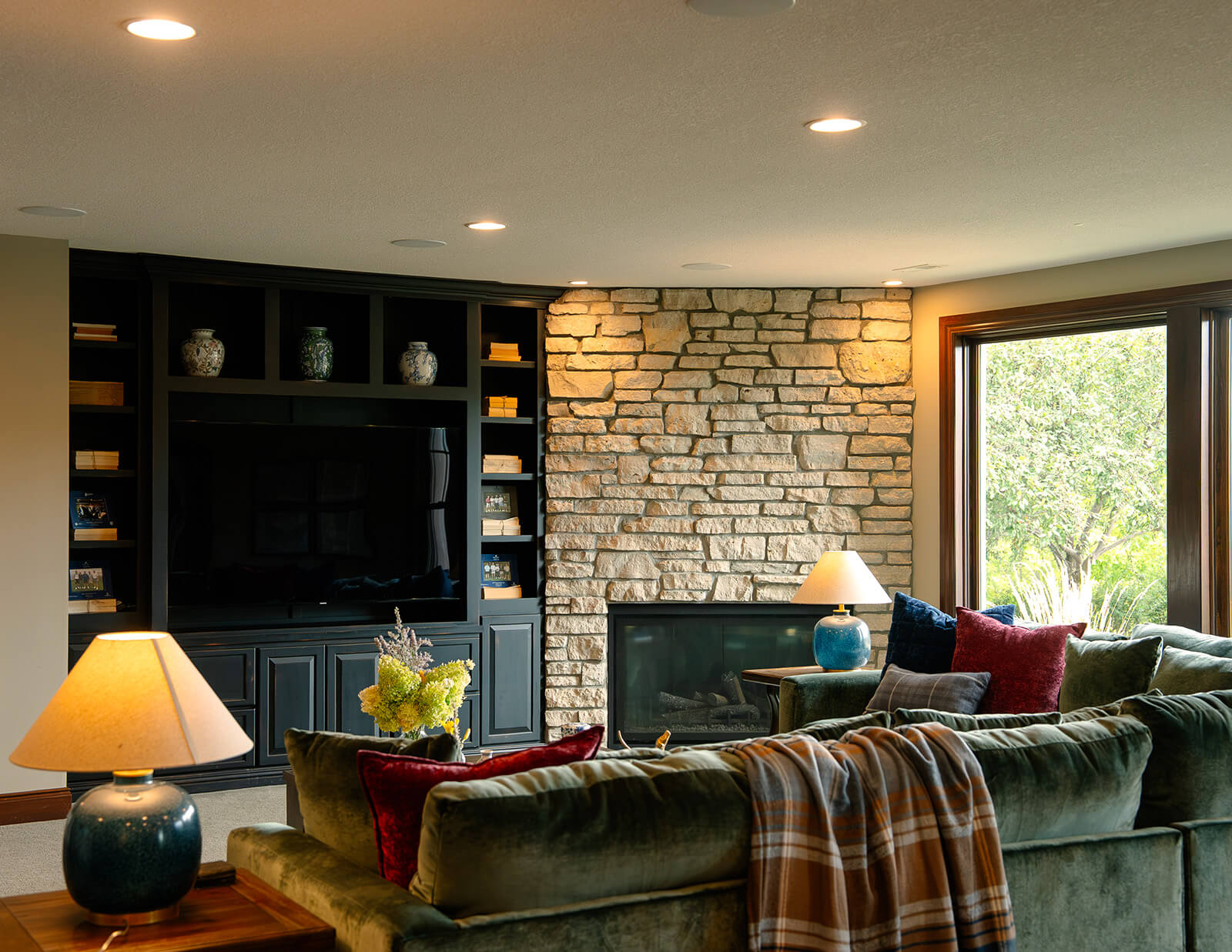 design-by-your-side-living Elevated rustic living room with emerald green sofa and cozy furnishings