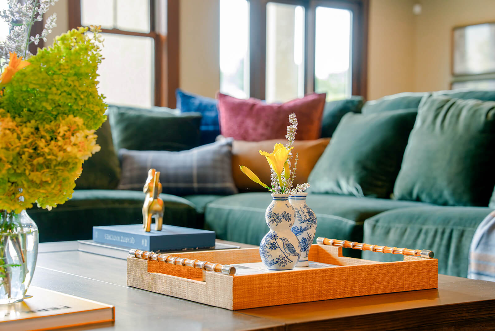 taylor-jane-project-10 Layered living room with deep green and burgundy pillows, soft textiles, and natural light