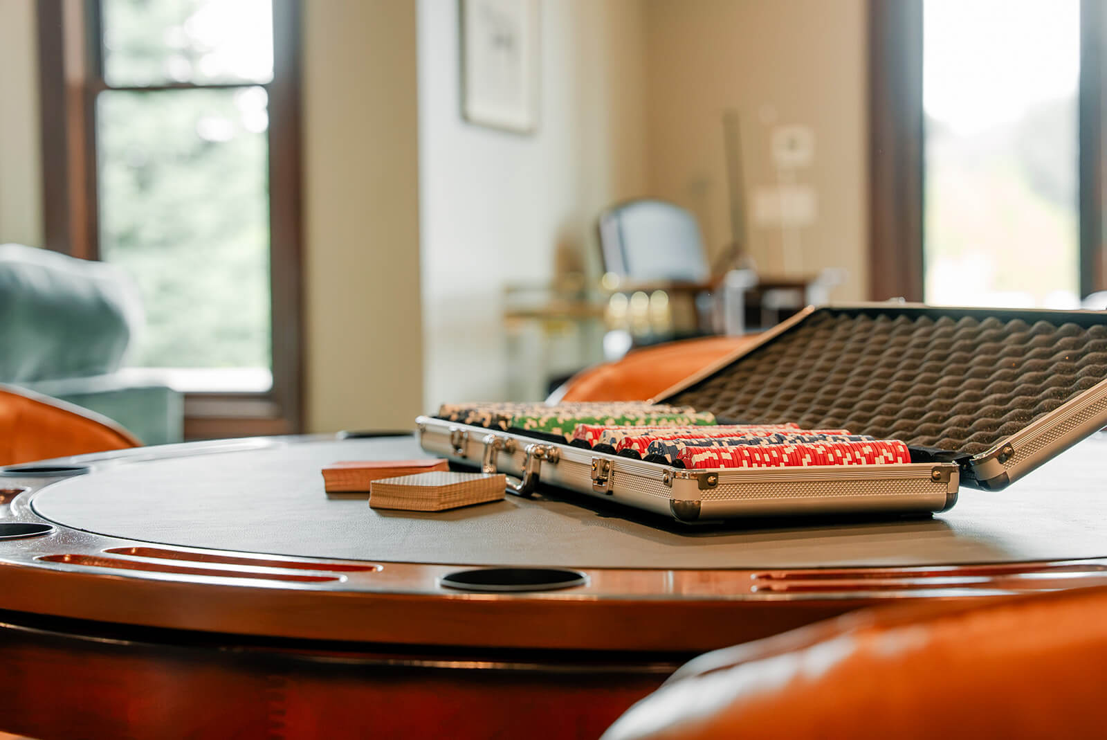taylor-jane-project-11 Close-up of a rustic poker table with a metal case of poker chips, adding a playful touch to the space