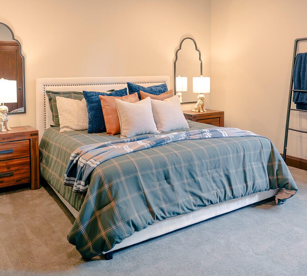 taylor-jane-project-22 Serene bedroom with layered blue and white bedding, soft neutral walls, and elegant traditional furnishings