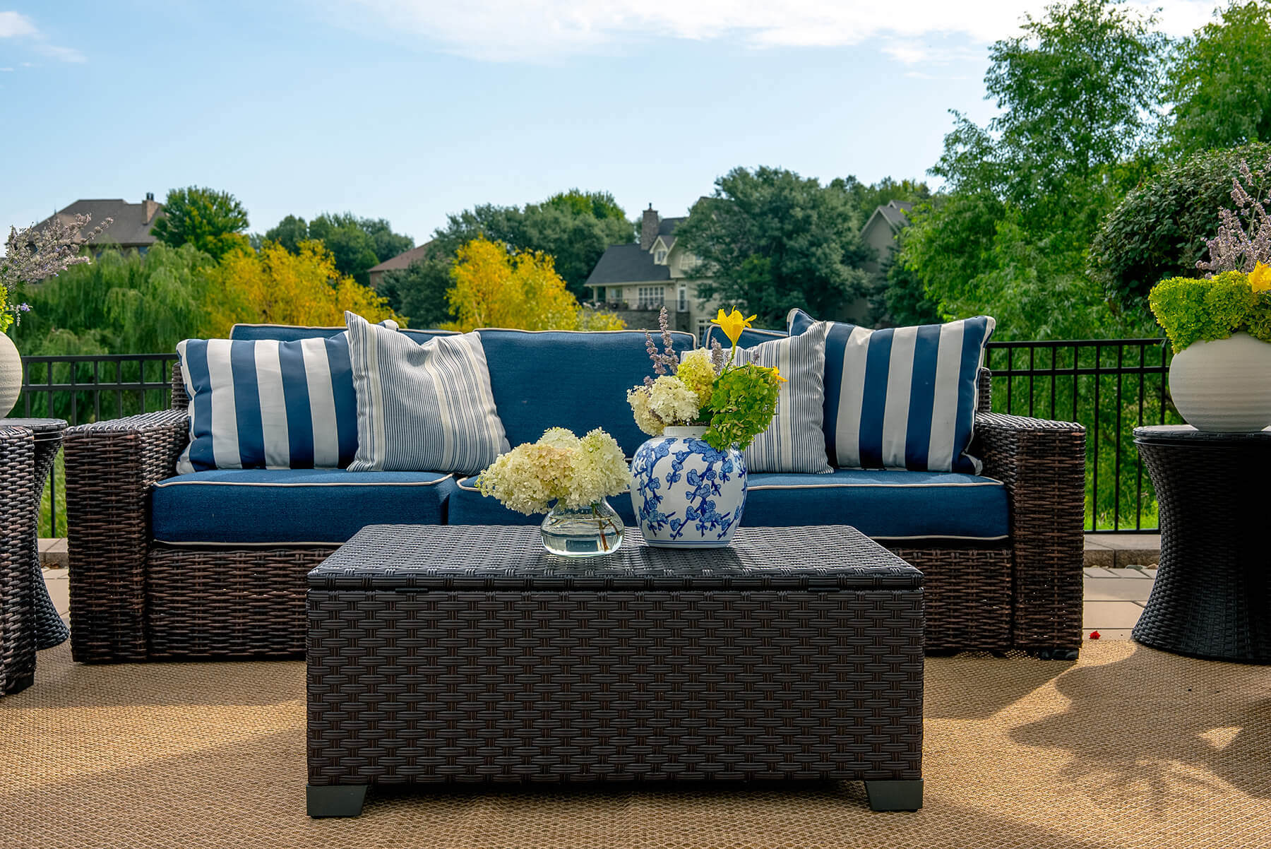 taylor-jane-project-27 Classic outdoor sofa with blue-and-white striped pillows, fresh hydrangeas, and a relaxed garden setting