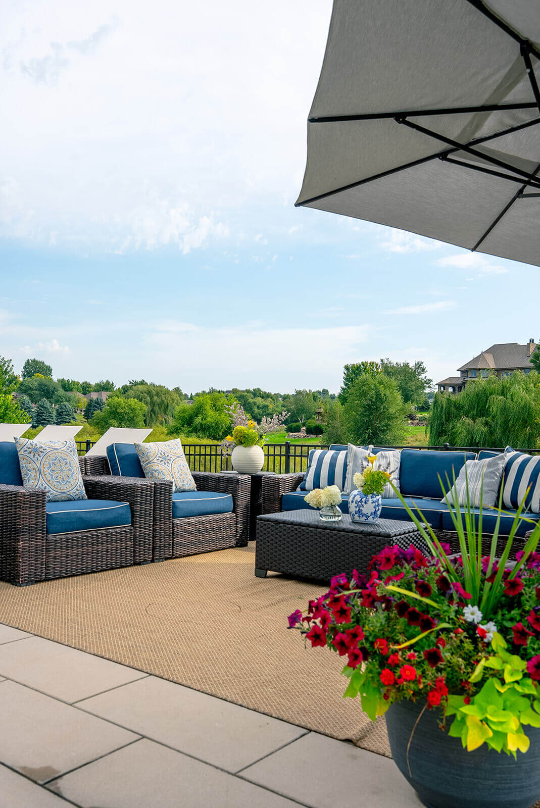 taylor-jane-project-31 Relaxed outdoor lounge with blue-and-white seating, striped pillows, and expansive views of the landscaped yard