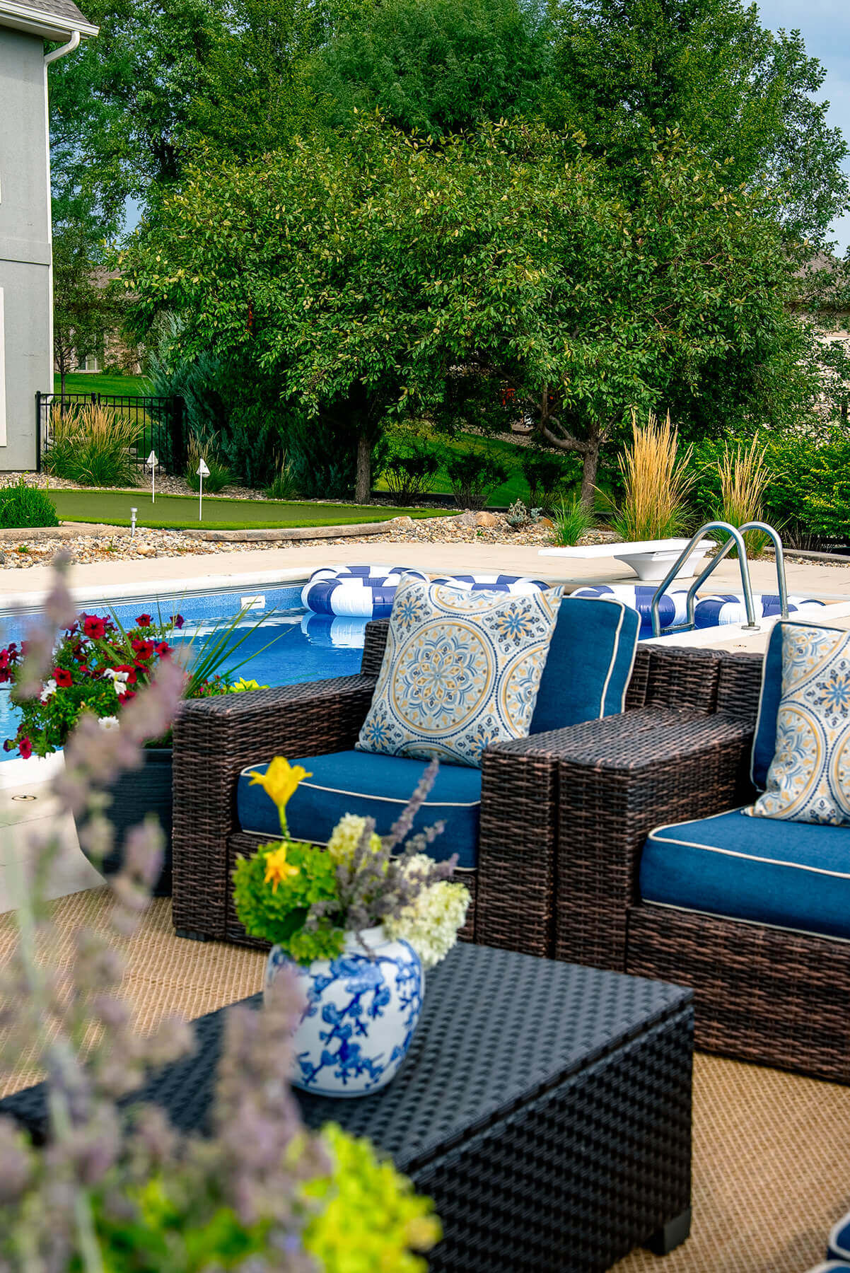 taylor-jane-project-34 Inviting outdoor seating area with blue cushions, patterned pillows, and lush greenery overlooking the pool