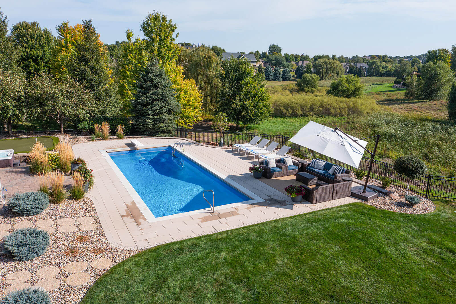 taylor-jane-project-35 Elevated pool area with blue water, white loungers, and landscaped grounds creating a refined outdoor retreat