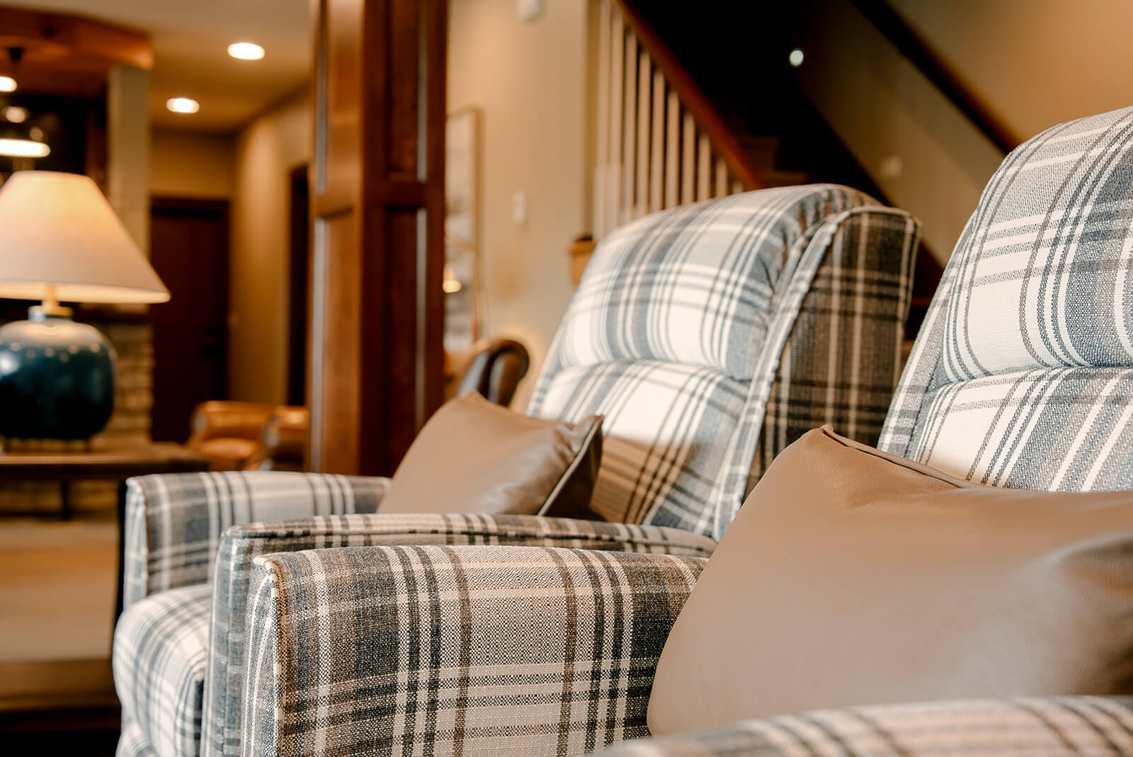 taylor-jane-project-7 Classic lounge chair with soft plaid upholstery surrounded by rich wood and warm neutral tones