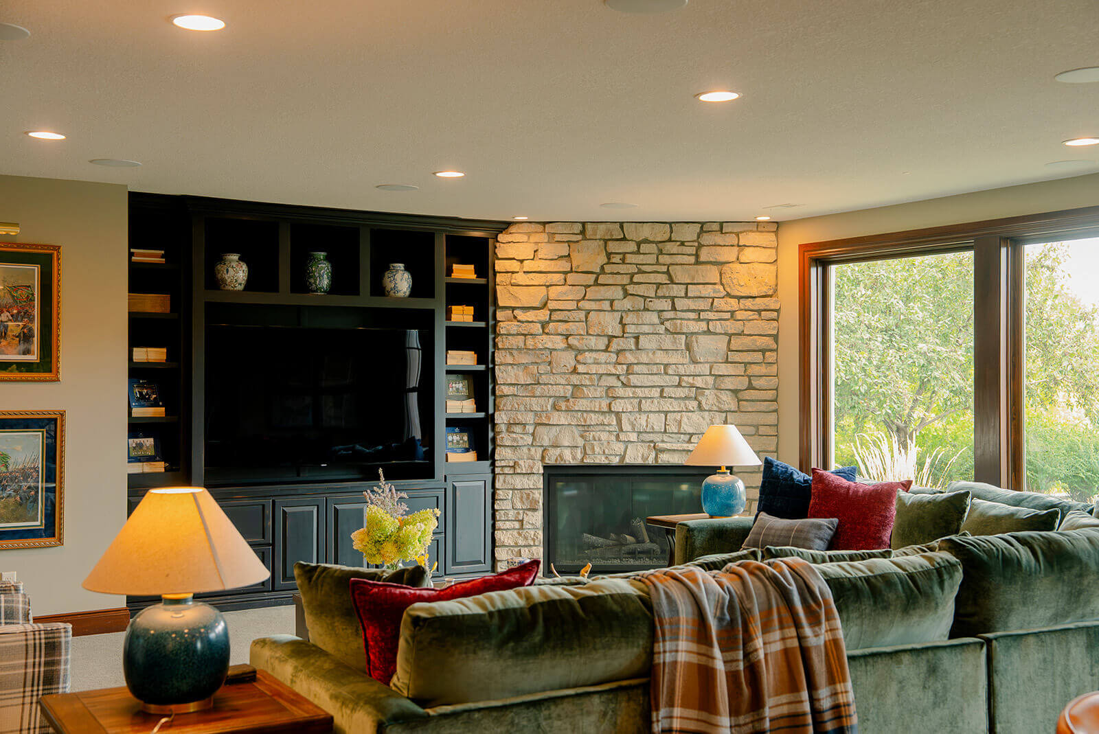 taylor-jane-project-9 Rustic living room with stone fireplace, dark furnishings, and warm wood architectural details