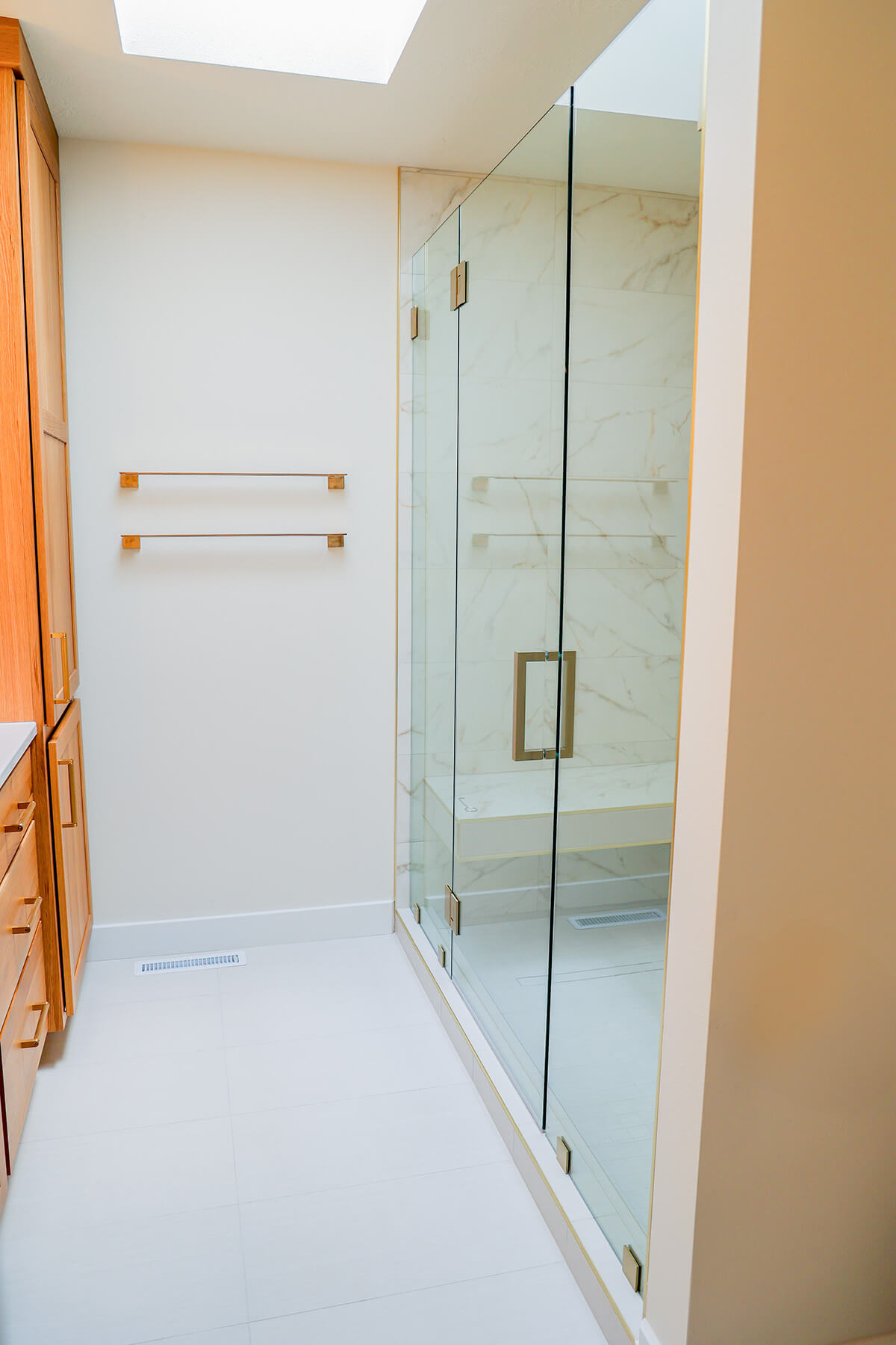 the-fairway-project-1 Elevated walk-in shower with gold fixtures and towel racks