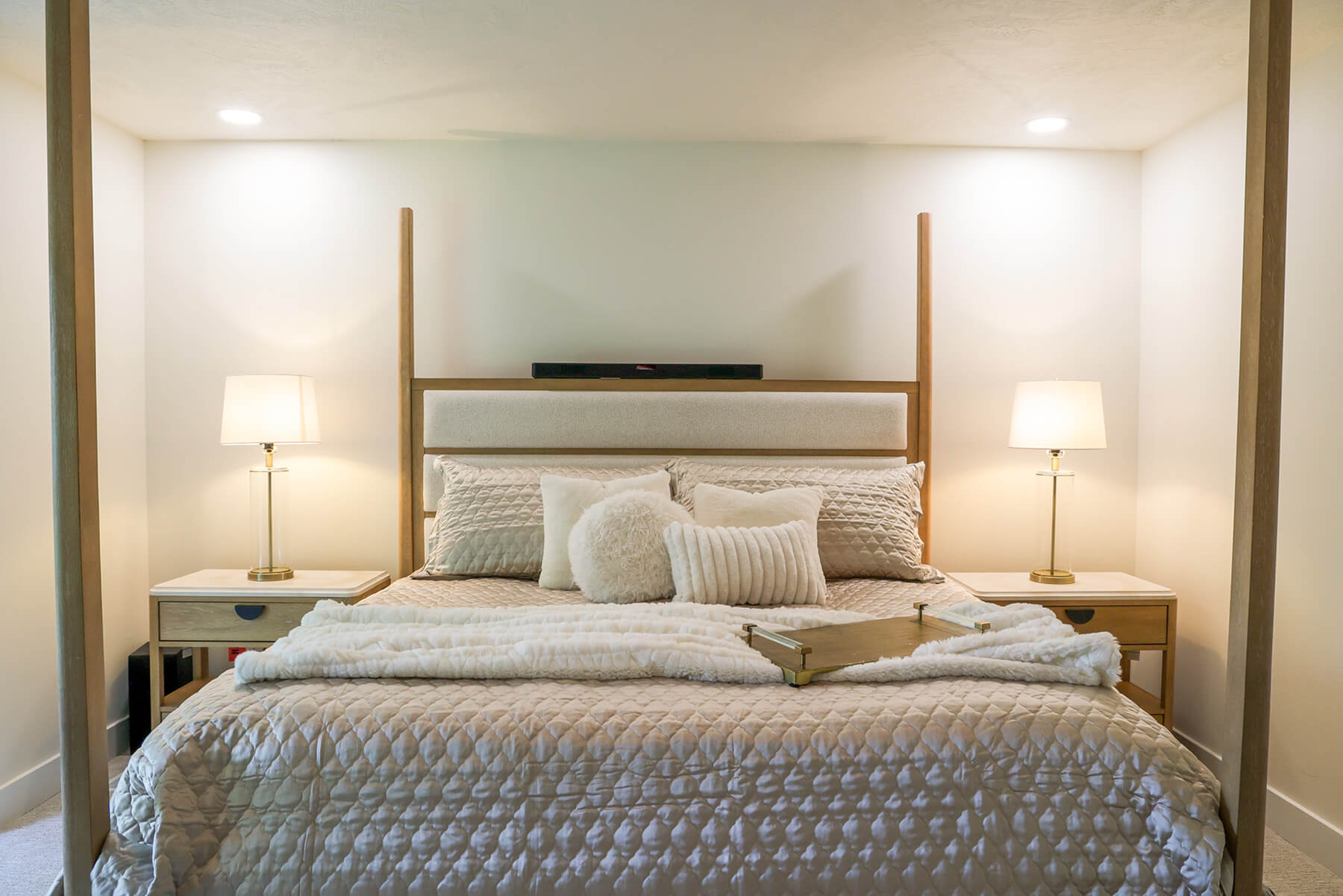 the-fairway-project-12 Warm wood tone bedroom featuring a four-post bed frame and white quilted bedding
