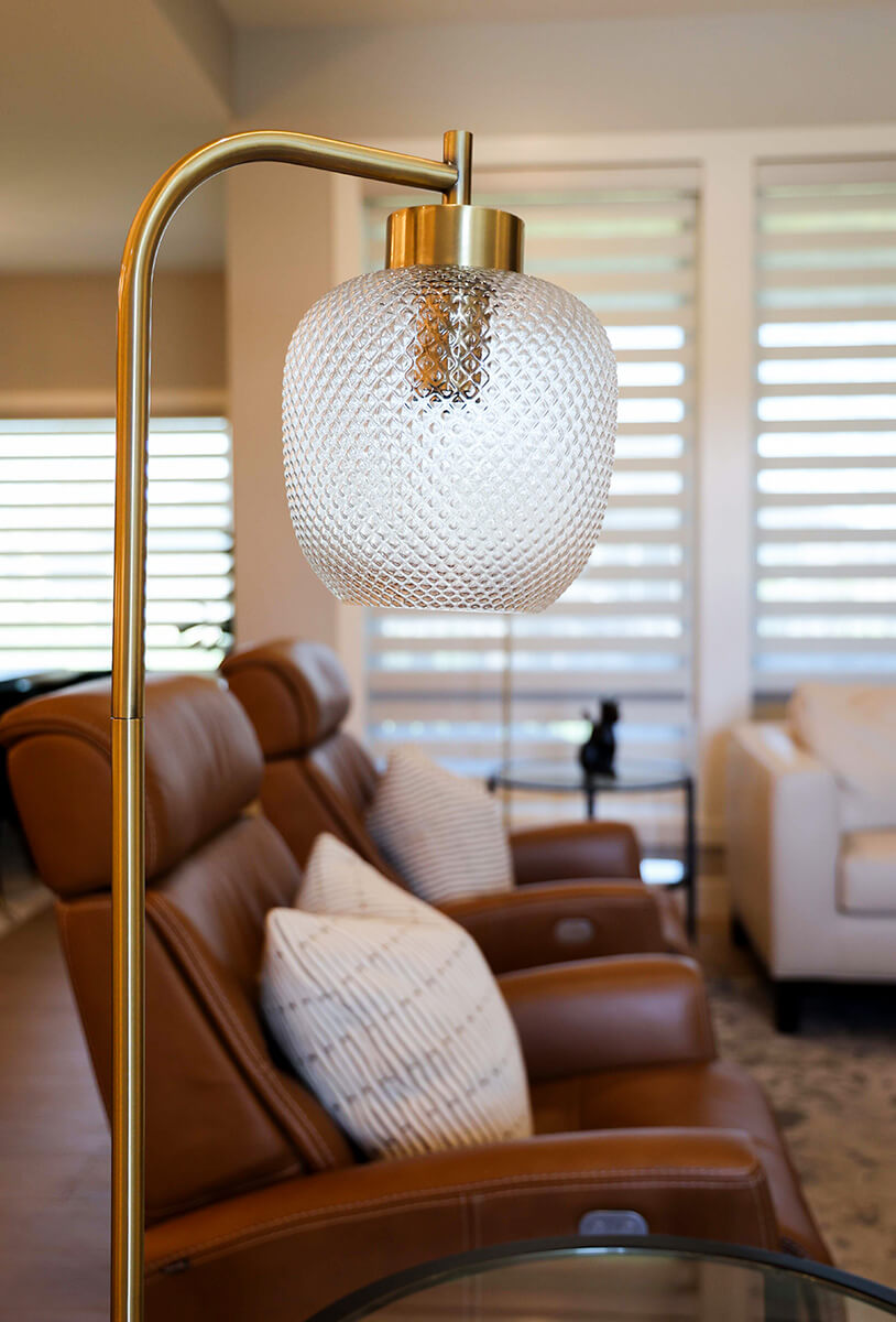 companion-project-1 Cozy living room with leather chairs, patterned pillows, and a modern brass floor lamp