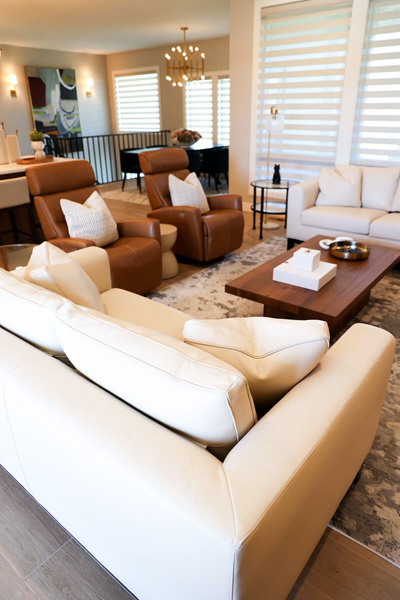companion-project-4 Bright living room with cream sofa, leather chairs, and warm wood accents