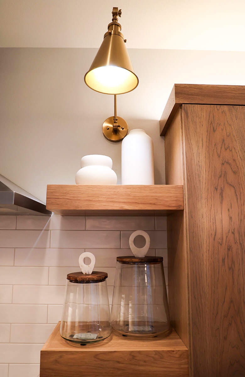 companion-project-5 Wood console cabinet styled with ceramic vases, books, and a brass pendant light