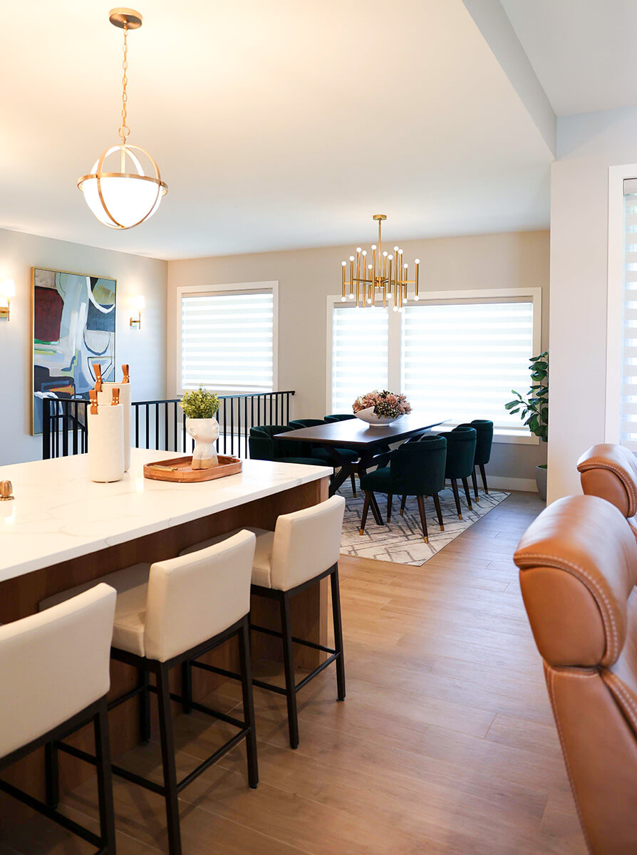 companion-project-6 Open dining area with a long wood table, upholstered chairs, and modern pendant lighting