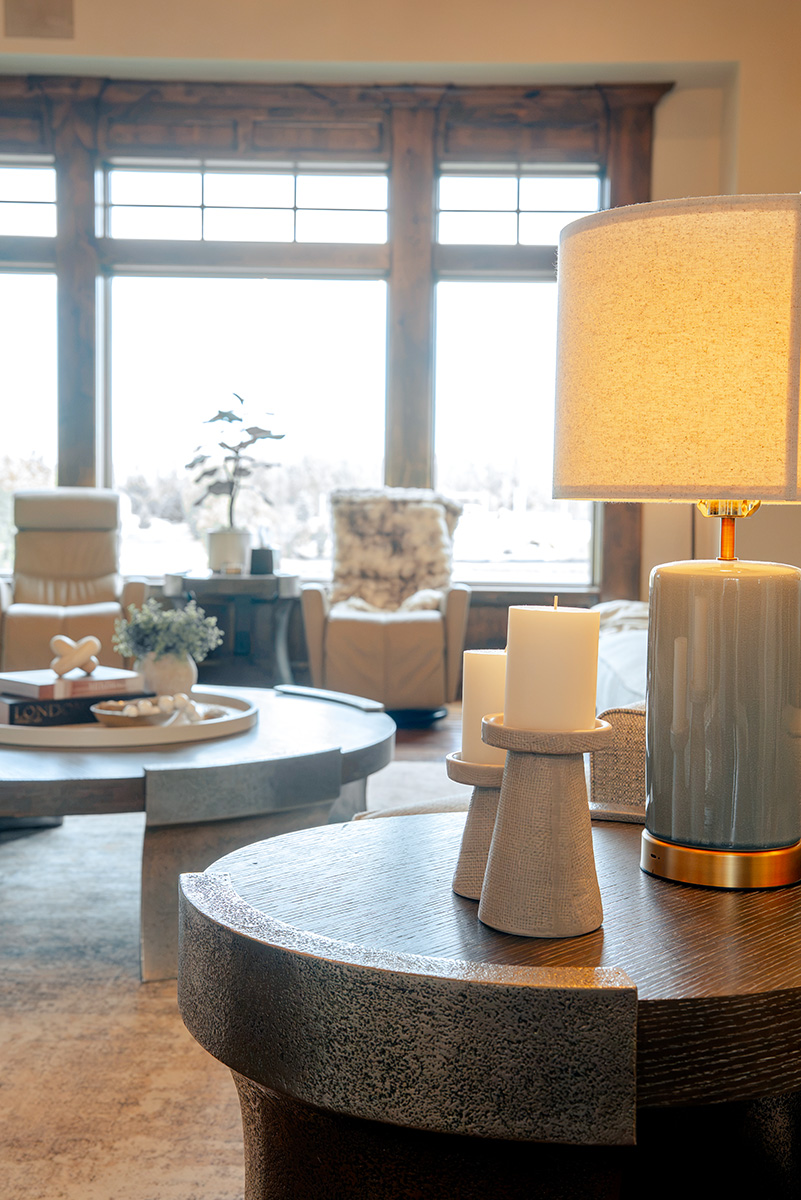 hearth-project-add-1 Warm living room with layered seating, wood accents, and a large table lamp