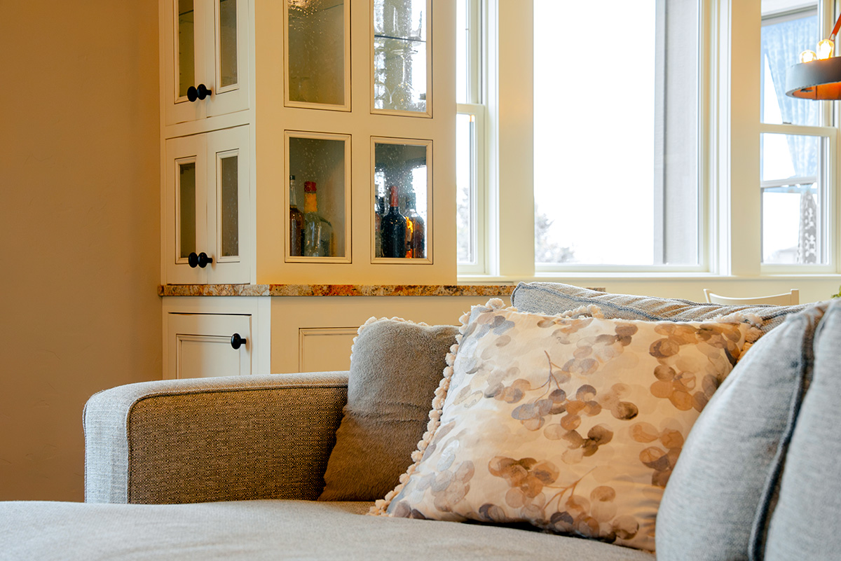 hearth-project-add-3 Light-colored sofa with a patterned accent pillow and built-in display shelving