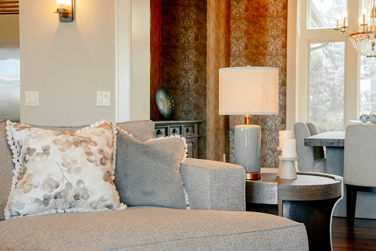 hearth-project-add-7 Light-colored sofa with patterned pillows, side tables, and a warm table lamp