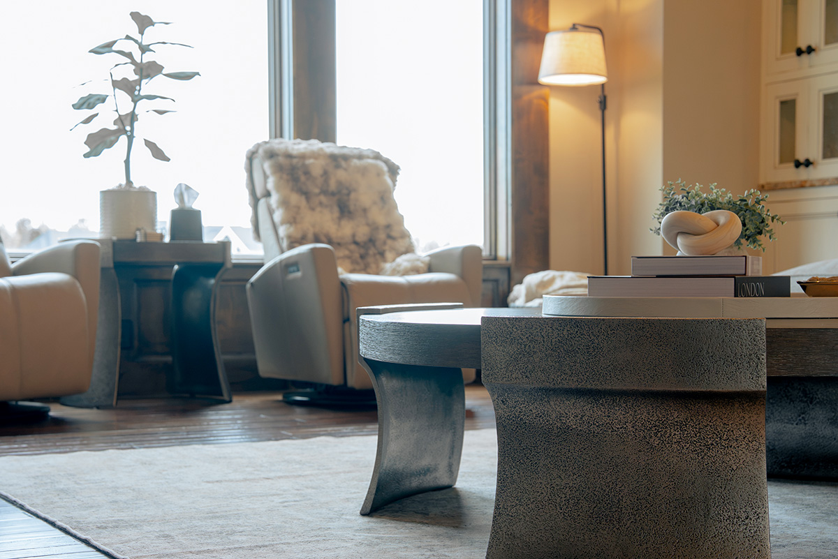 hearth-project-add-8 Neutral living room with rounded coffee table, upholstered chairs, and large windows