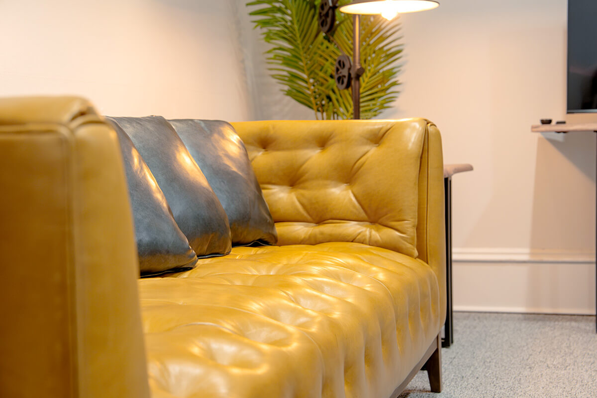 principle-properties-project-7 Mustard yellow leather sofa in a bright, modern office lounge
