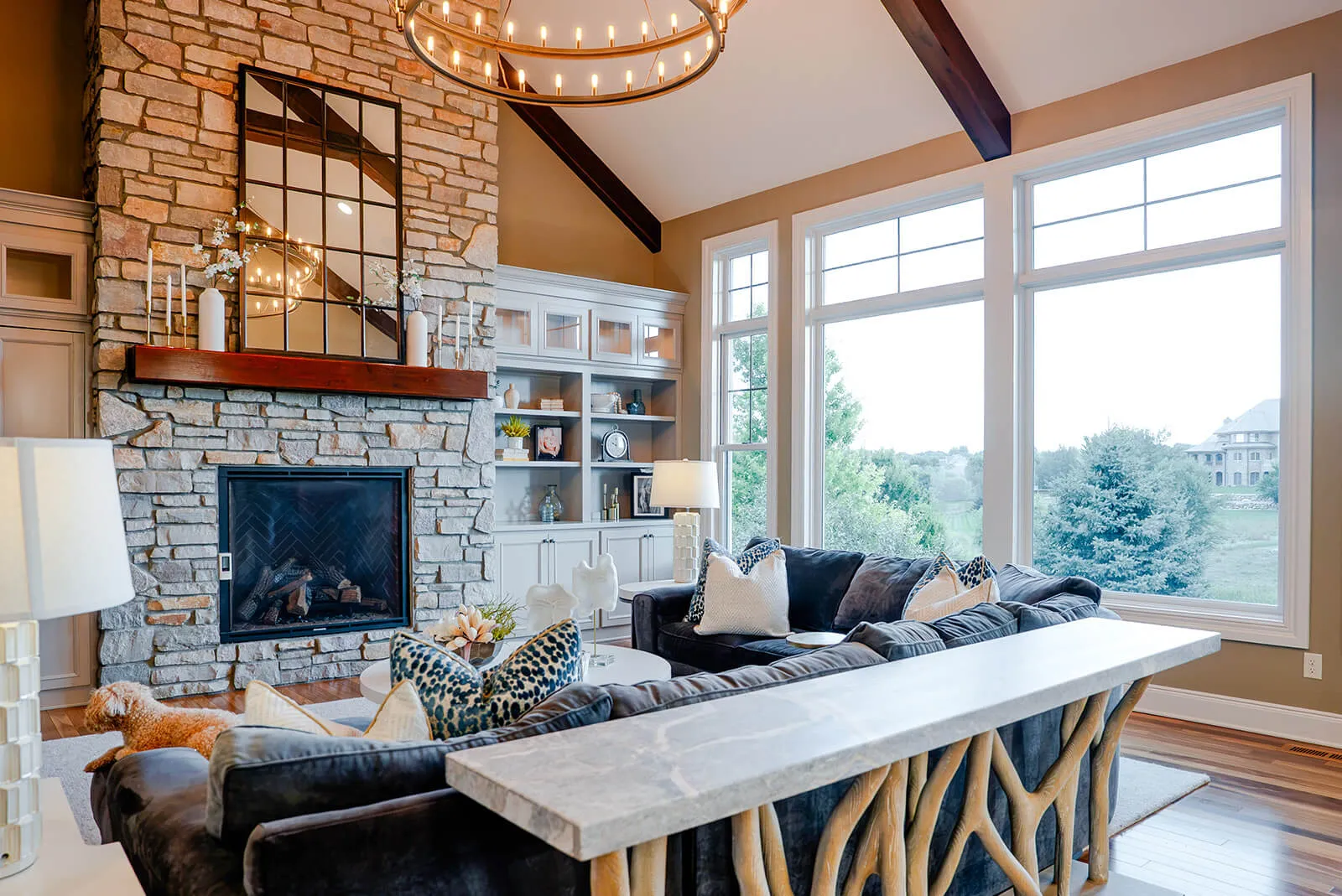 taylor-jane-project-40 Open living space with expansive windows, exposed wood beams, and sophisticated rustic furnishings
