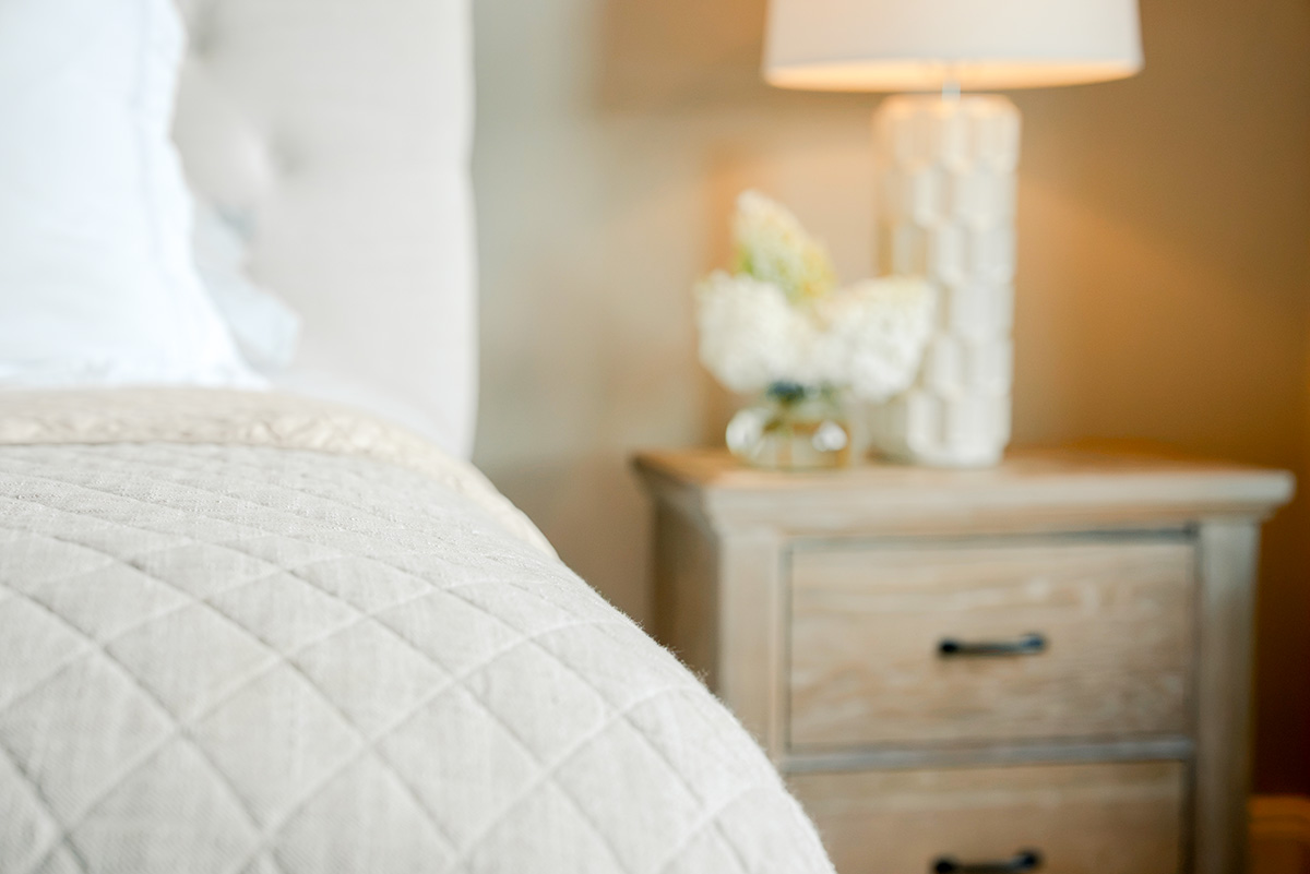 taylor-jane-project-51 Neutral bedroom with quilted bedding, wood nightstand, and table lamp