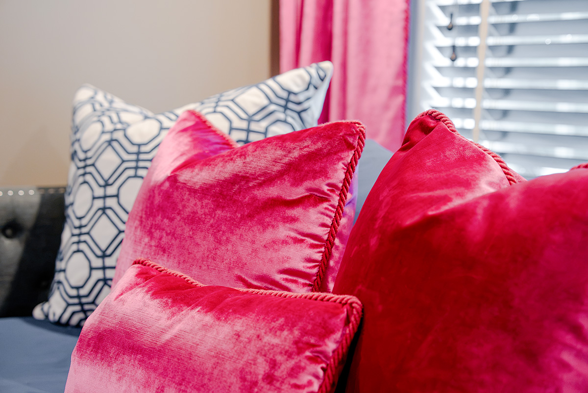 taylor-jane-project-55 Bright pink and patterned accent pillows on a living room sofa